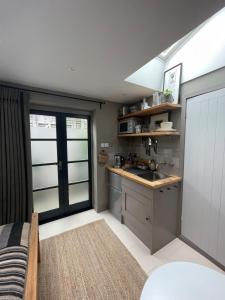 a small kitchen with a sink and a counter at Studio 77 Cheltenham in Cheltenham +5 photos