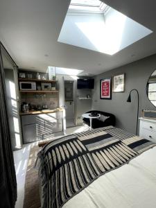 a bedroom with a large bed with a skylight at Studio 77 Cheltenham in Cheltenham