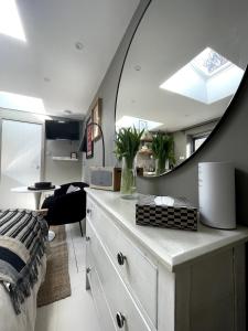 a bedroom with a mirror and a dresser with a desk at Studio 77 Cheltenham in Cheltenham