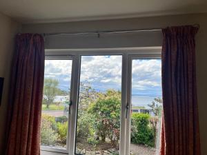 a sliding glass door with a view of the ocean at The Rowans B&B in Connel