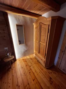 an empty room with a cabinet and wooden floors at L'Antico Piol de Feltre in Feltre
