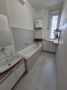 a white bathroom with a tub and a sink at LP 1926 aneb U nás doma in Zlín