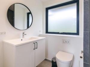 a white bathroom with a sink and a mirror at Kysthusene in Gilleleje