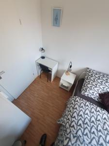 a bedroom with a bed and a desk with a table at Angenehmes privatzimmer in Cologne