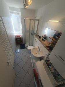 a bathroom with a sink and a shower and a toilet at Angenehmes privatzimmer in Cologne