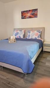 a bedroom with a bed with blue sheets and pillows at House Nena in Bibinje