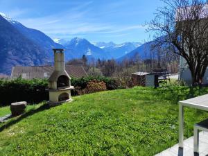 a small oven in a field with mountains in the background at Casa Laetitia in Acquarossa +3 photos