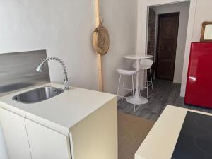 a kitchen with a sink and a red refrigerator at azul rooms & suites in Olbia +66 photos