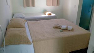 two beds in a room with towels on them at Casa do Pepe em Barra de Jacuípe in Camaçari +15 photos