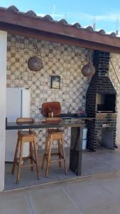 a kitchen with a table and two stools and an oven at Casa do Pepe em Barra de Jacuípe in Camaçari