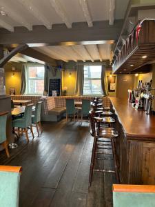 a restaurant with a bar and tables and chairs at The willow tree inn in Pilsley