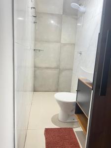 a white bathroom with a toilet and a shower at Apt estiloso 01 in Paragominas