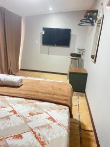 a bedroom with a flat screen tv on the wall at Apt estiloso 01 in Paragominas