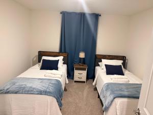 two beds in a room with blue curtains at Paradise in the Springs in Citrus Springs