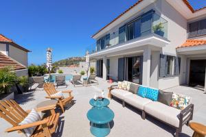 a patio with a couch and chairs in front of a house at Villa Macedo in Ponta do Sol