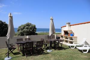 a table and chairs with umbrellas and the ocean at DUPLEX JUNTO AL MAR in Oia