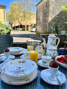 a table with plates and cups and a teapot at Chez Lapage in Saint-Avit-Sénieur