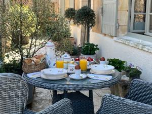 a table with plates of food and orange juice at Chez Lapage in Saint-Avit-Sénieur