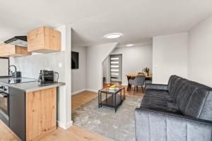 a kitchen and living room with a couch and a table at Platinum Elite Residence in Rybnik