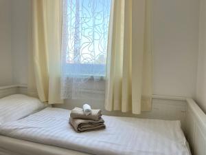 a bed with towels on it with a window at Apartmani Drago in Vir
