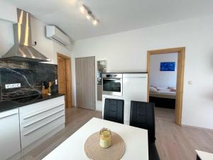 a kitchen and dining room with a table and chairs at Apartmani Drago in Vir
