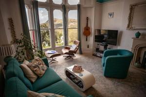 a living room with a green couch and chairs at Sea View Ultimate Boutique escape! in Barnstaple