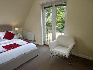 a bedroom with a bed and a chair and a window at 12A-1 Stobhill Road in Arniston