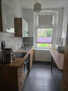 a kitchen with a sink and a window at Ferienwohnung 1 am Bahnhof in Bernburg