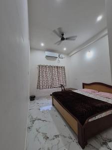 ein Schlafzimmer mit Bett und Deckenventilator in der Unterkunft Hotel Seva Simran in Chhatarpur