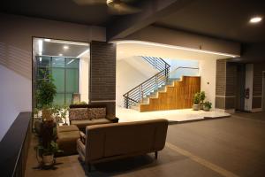 a living room with a couch and a staircase at Pearl Serenity in Sholāshahar