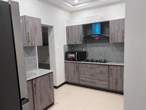 a kitchen with wooden cabinets and a microwave at Bridge Residency in Islamabad +31 photos