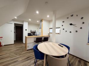 a room with a table and chairs and a clock on the wall at Famille in Sumoto +30 photos