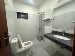 a bathroom with a toilet and a sink at Bridge Residency in Islamabad