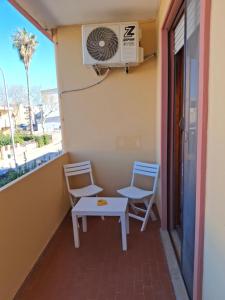 a balcony with two chairs and a table and a heater at NEN's House in Alghero