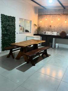 a wooden table and benches in a kitchen at Casa de piscina Pôr do Sol in Chapadão do Sul