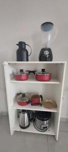 a white shelf with pots and pans on it at Casa de piscina Pôr do Sol in Chapadão do Sul