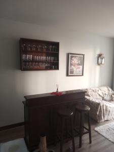 a living room with a bar and two stools at Quarto no apartamento do anfitrião na Praia do Canto in Vitória