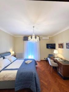 a bedroom with a bed and a desk and a chandelier at CuordiSole Tuscany in Montopoli in Val dʼArno +56 photos