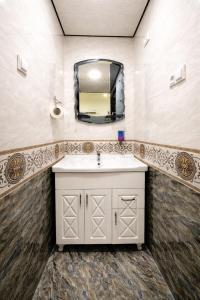 a bathroom with a sink and a mirror at Colibri Traditional Hostel in Samarkand +16 photos