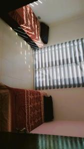 a room with a bed and a window with blankets at Taj Plaza in Sowayma