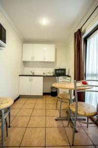 a kitchen with a table and chairs in it at Pialba Motor Inn in Hervey Bay