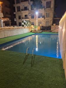a swimming pool at night with two metal rails in the grass at Taj Plaza in Sowayma +10 photos
