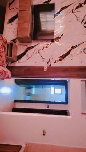 a kitchen with a window and a marble wall at Taj Plaza in Sowayma