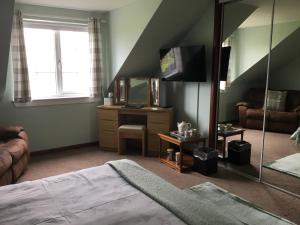 a bedroom with a bed and a mirror at Woodcockfaulds House in Stirling