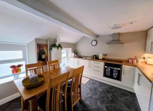 a kitchen with a wooden table and chairs in a kitchen at Boutique Ensuite Studios in Aberystwyth