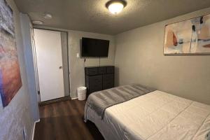 a bedroom with a bed and a flat screen tv at Value Rental no frills in Midvale