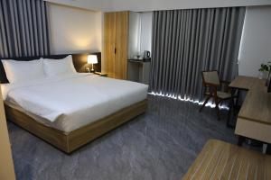 a hotel room with a large bed and a table at Pearl Serenity in Sholāshahar