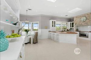 a kitchen with a large island and a clock on the wall at Peninsula Farm Stay in Somerville