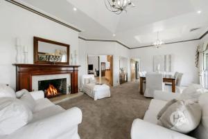 a living room with white furniture and a fireplace at Peninsula Farm Stay in Somerville