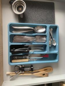 a blue tray filled with utensils on a counter at T2 cyclamen independent in Cholet